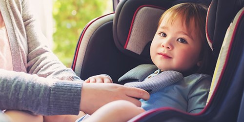 Child being strapped into car seat